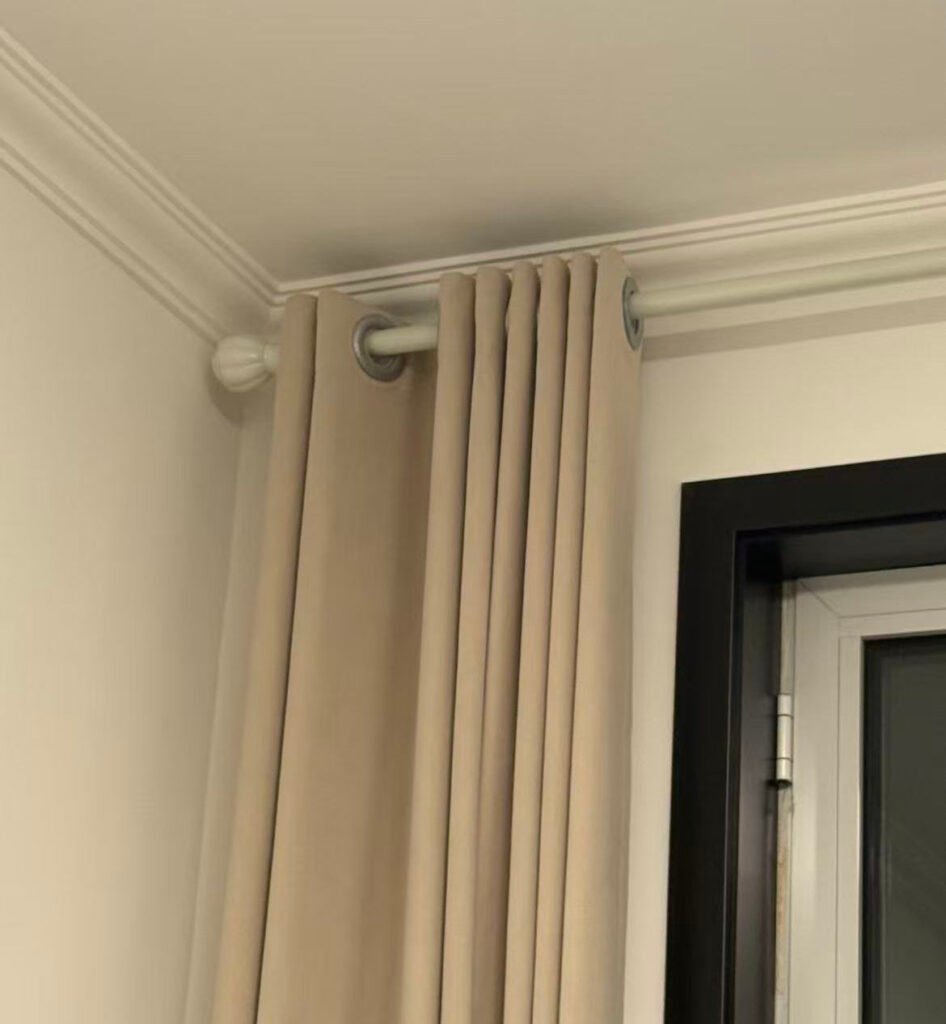 A side-by-side comparison showing a decorative curtain rod with rings and a discreet ceiling-mounted curtain track