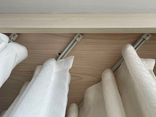 A close-up shot of a durable aluminum track profile with wheeled gliders