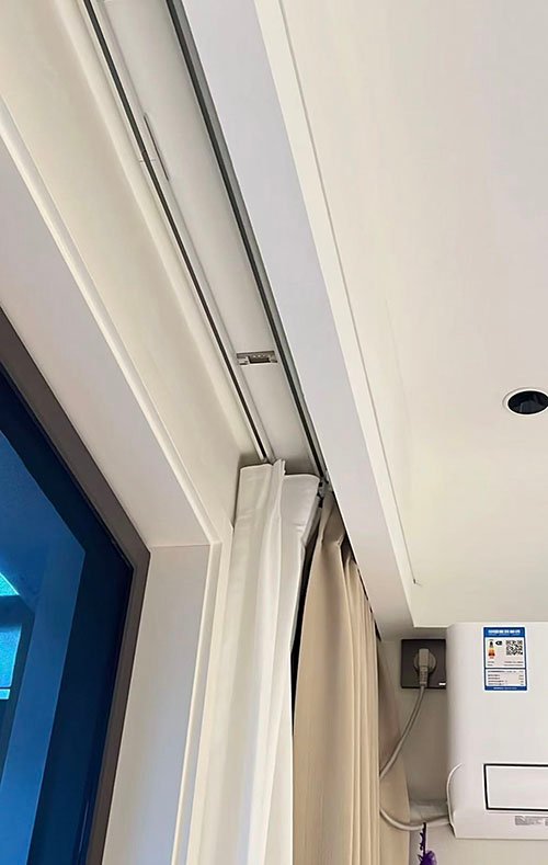 Heavy-duty commercial curtain track supporting blackout drapes in a theater