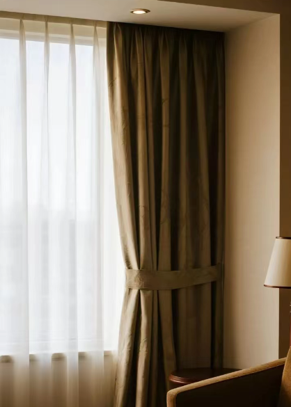 a hotel cleaner wiping down a curtain track